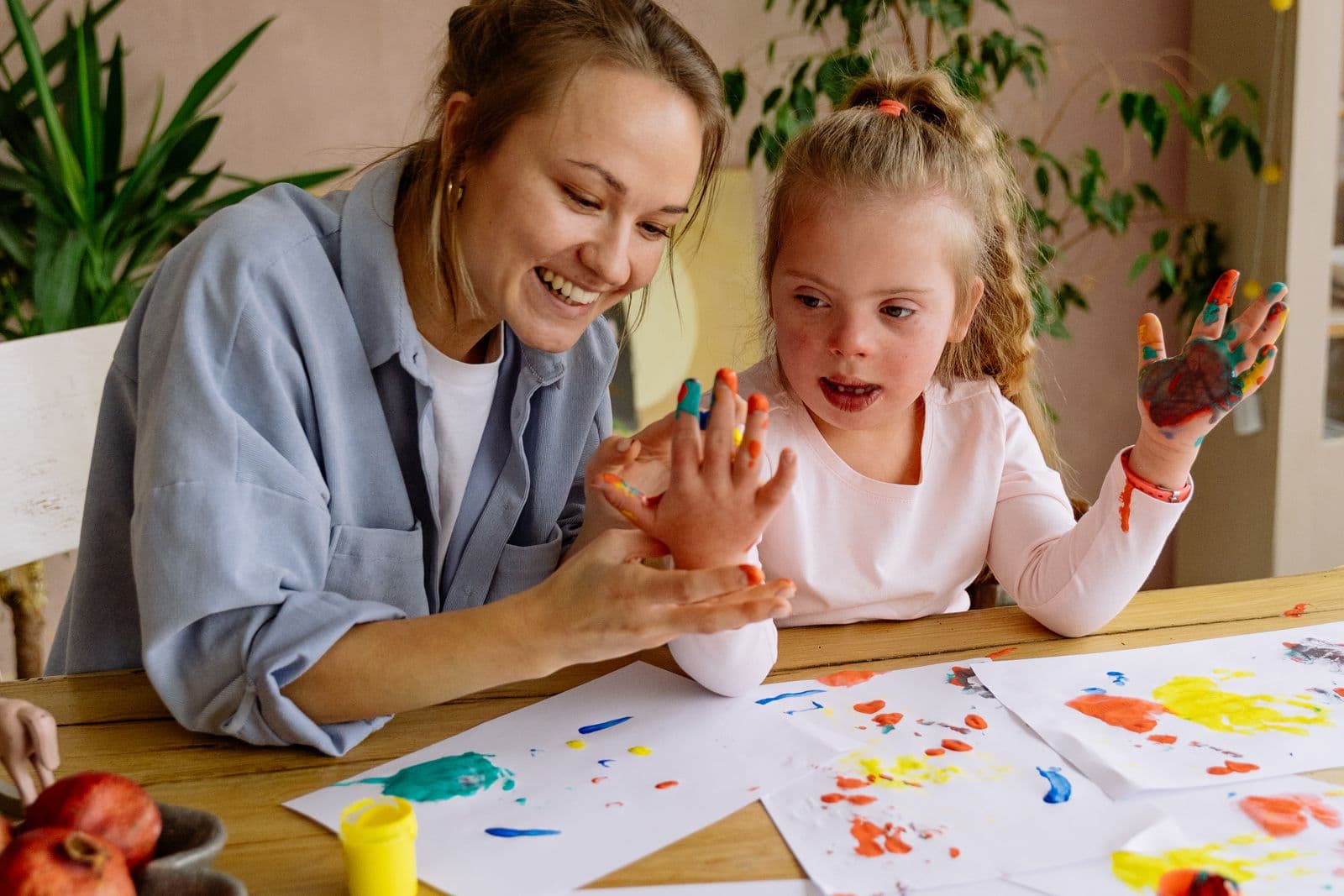 A support worker doing arts and crafts with a young person with a learning disability.